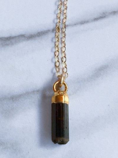 RAW BLACK TOURMALINE NECKLACE. Free-form raw black tourmaline electroplated in recycled brass with 24K gold overlay. Hangs delicately from a 14K gold filled 18" chain. Approx. 10mm in length.