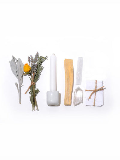 This Ritual Kit includes: White chime candle, Ceramic candle holder, Selenite and quartz crystal, A mini bouquet with rose, lavender, and cedar, California white sage stick, and Holy palo santo wood from South America.