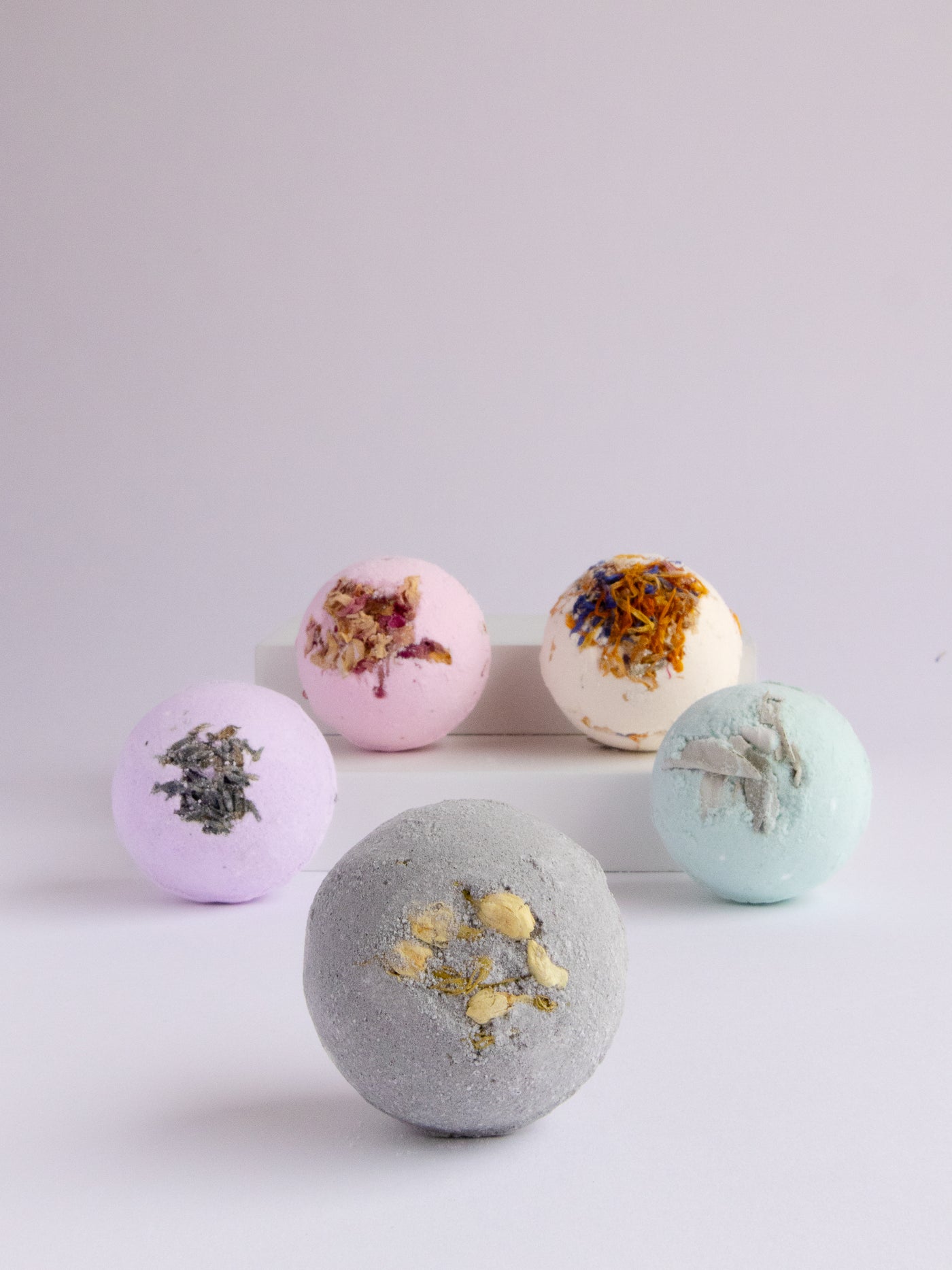 Jasmine Cole bath bomb is made with coconut oil, dried jasmine, and activated charcoal. Handmade in Ojai, CA.
