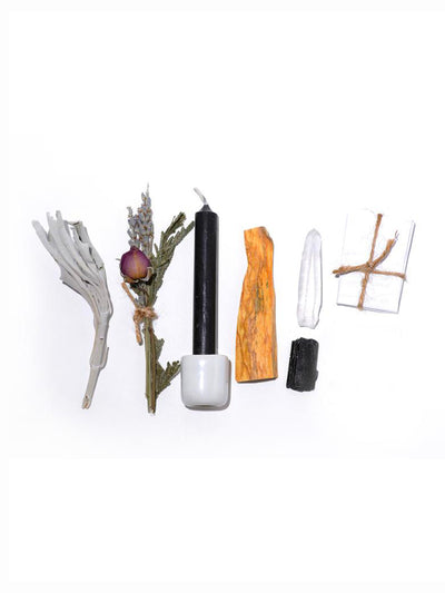 This Ritual Kit includes: Black chime candle, Ceramic candle holder, Black Tourmaline and quartz crystal, A mini bouquet with rose, lavender, and cedar, California white sage stick, and Holy palo santo wood from South America.