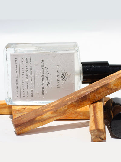 RUTILATED QUARTZ CRYSTAL INFUSED PALO SANTO ROOM + LINEN MIST with notes of rosewood, sage, nutmeg, rose, frankincense, and lemon.