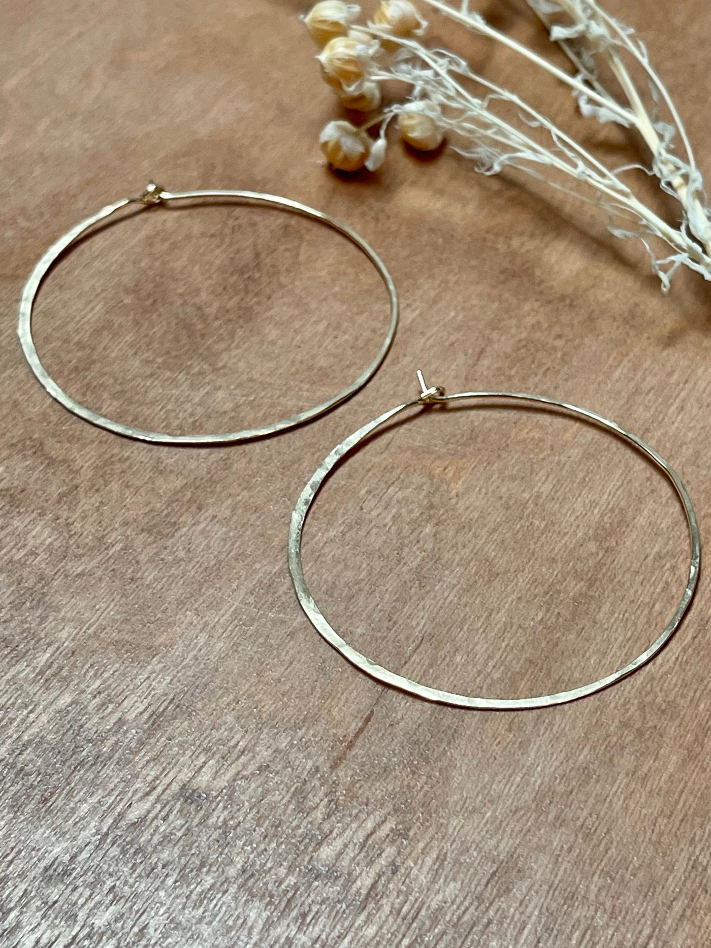 Gold Extra Large Crescent Moon Hoops. Made of lightweight hammered 14k yellow gold fill these measure 2 inches across.